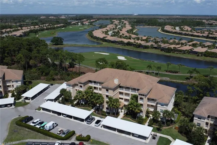 Aerial perspective of suburban area featuring a local golf course and a nearby body of water