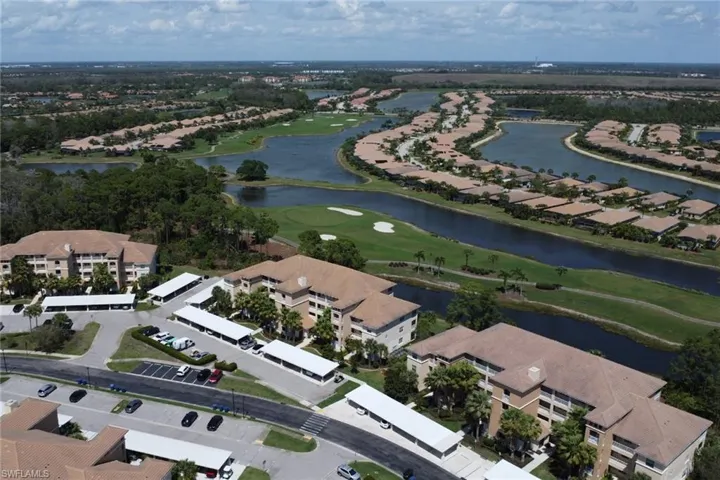 Aerial view of property's location with a golf course, a large body of water, and nearby suburban area