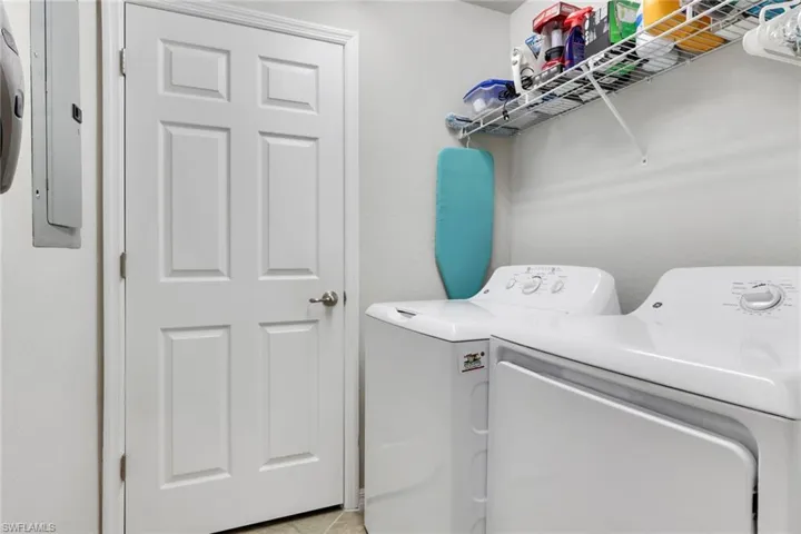 Laundry room featuring independent washer and dryer and electric panel