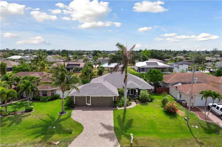 Aerial view of the front of the home presents a grand and welcoming entrance, with a well-maintained driveway leading up to a stately facade.