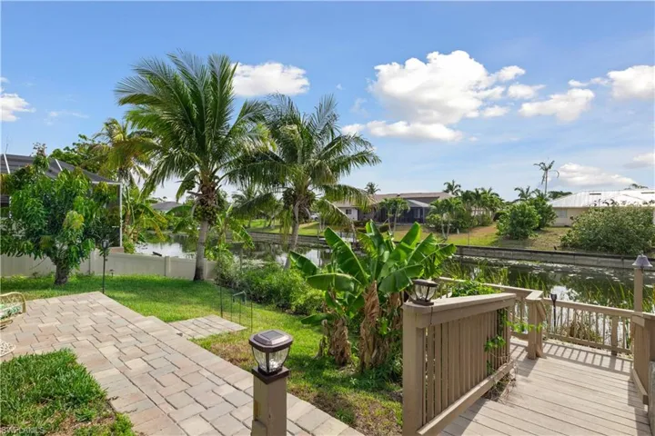 A beautifully paved pathway leads from the lanai to the canal, enhancing the seamless flow between outdoor spaces.