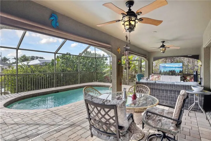 Step into your private outdoor oasis featuring a sparkling pool overlooking a peaceful canal.