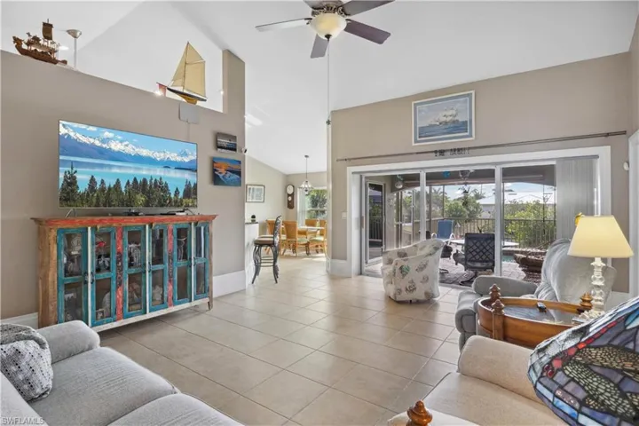 The living area offers stunning views of the pool and tranquil canal through expansive sliding glass doors, seamlessly blending indoor and outdoor living.