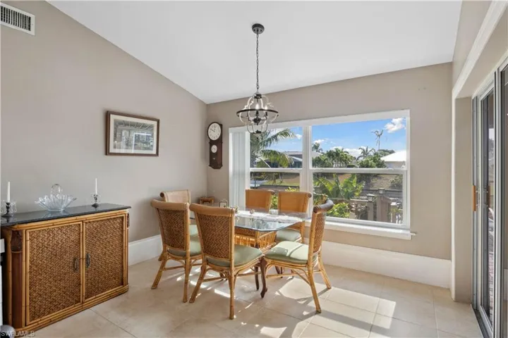 The dining area is a serene and inviting space, enhanced by a beautiful view of the canal just beyond large glass doors windows.