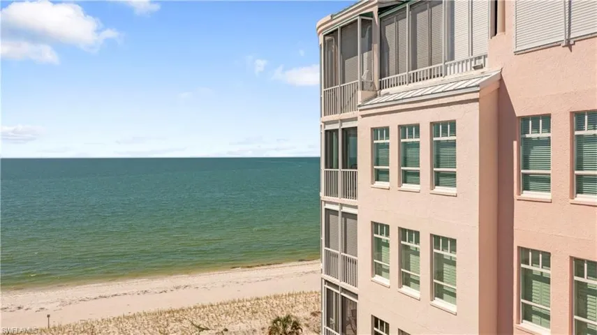 Water view with local beach and side view of residence building