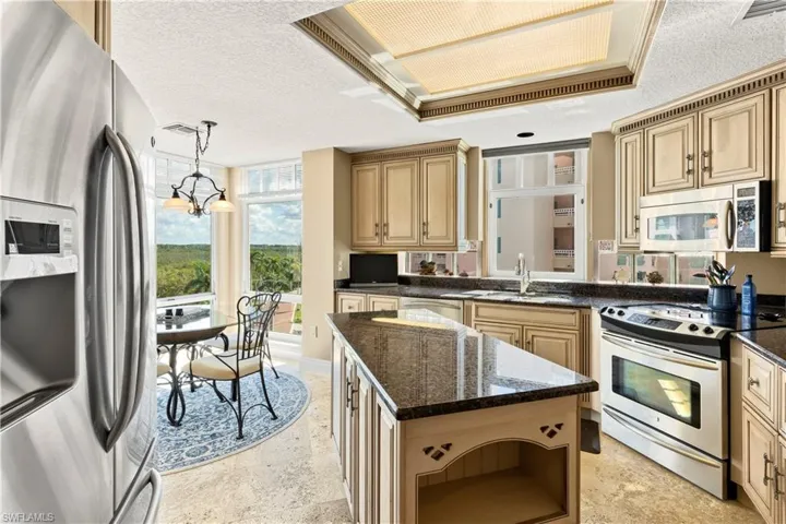 Kitchen with stainless steel appliances, a textured ceiling, open shelves, a chandelier, and pendant lighting