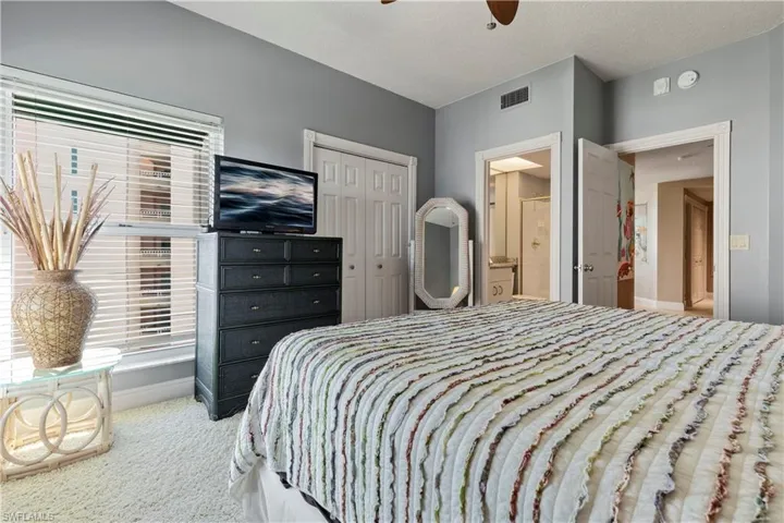 Bedroom with a closet, plush carpet floors, a ceiling fan, connected bathroom, and a textured ceiling