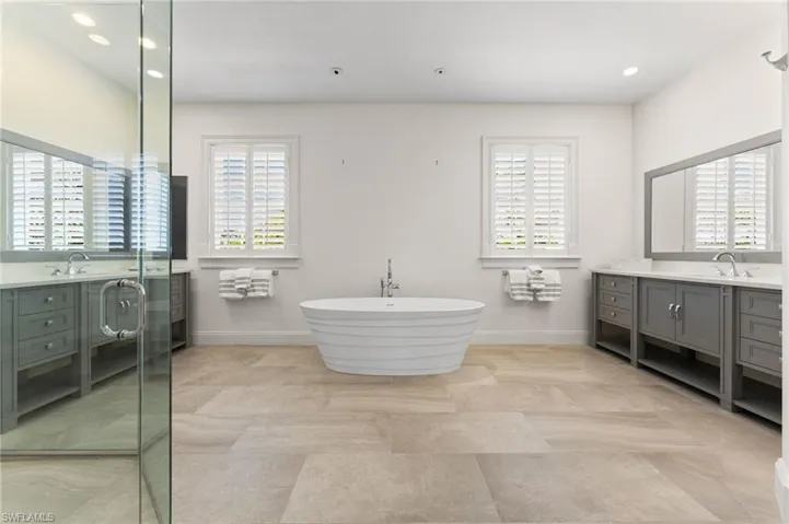 Bathroom with a soaking tub, a shower stall, vanity, recessed lighting, and baseboards