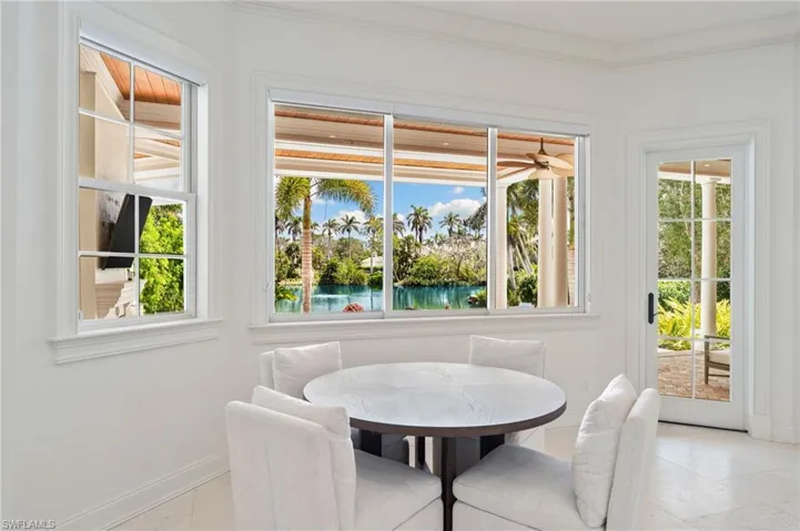 Dining room with a water view, baseboards, and crown molding