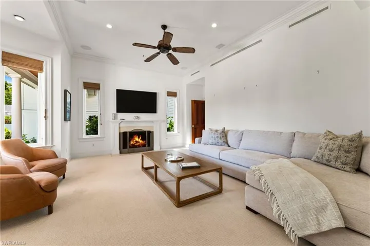Living room featuring crown molding, a healthy amount of sunlight, and visible vents