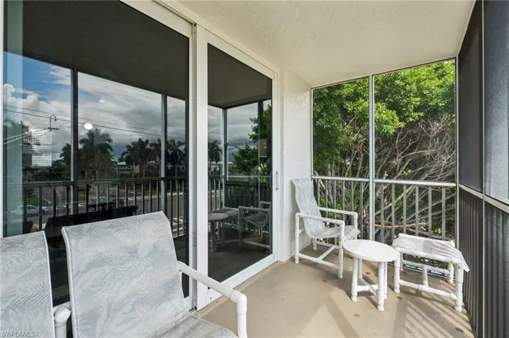 Screened balcony with sliding glass doors and concrete flooring