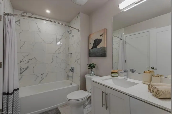Full bathroom with shower / bath combo with shower curtain and vanity