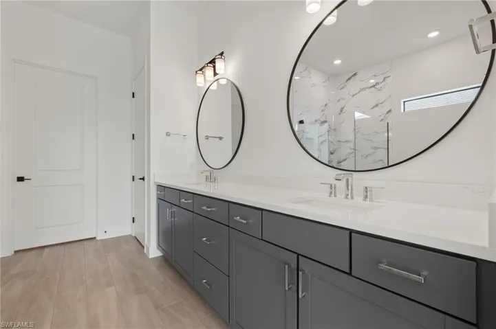 Bathroom featuring vanity, wood-type flooring, and a shower
