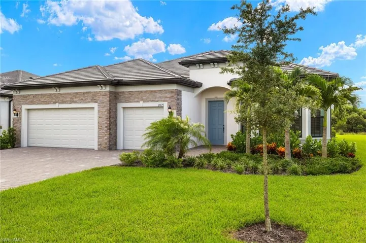 View of front of home with a garage and a front lawn