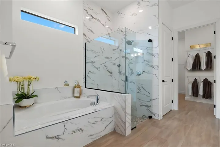 Bathroom featuring wood-type flooring and separate shower and tub