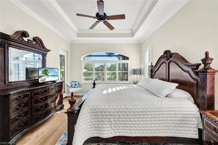 Bedroom with ceiling fan, light hardwood / wood-style floors, ornamental molding, and multiple windows