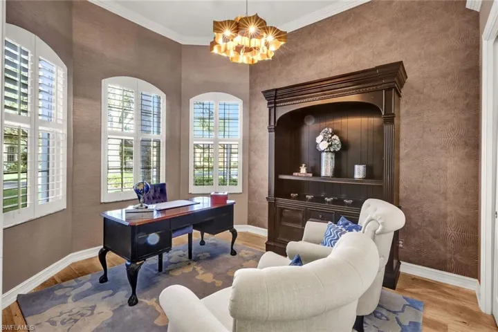 Home office with a chandelier, light hardwood / wood-style floors, plenty of natural light, and crown molding