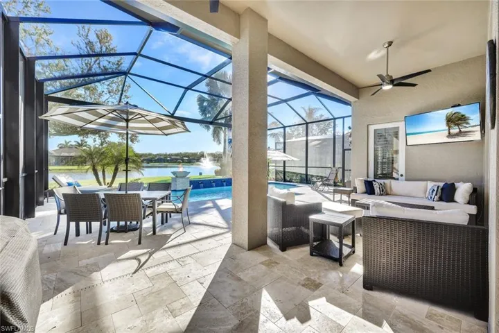 View of patio featuring an outdoor living space, glass enclosure, and ceiling fan