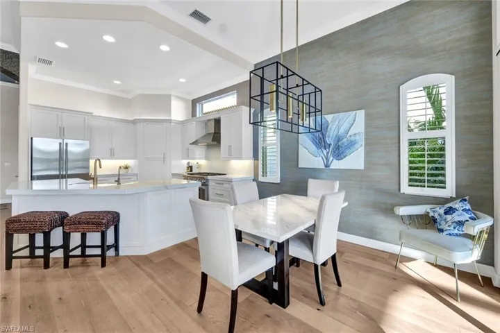 Dining space with sink, light hardwood / wood-style flooring, and ornamental molding