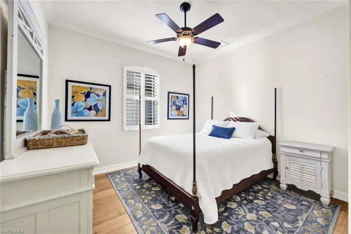 Bedroom with light wood-type flooring, ceiling fan, and ornamental molding