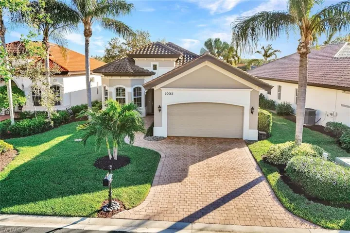 Mediterranean / spanish house with a garage, central air condition unit, and a front yard