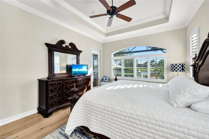 Bedroom featuring ceiling fan, ornamental molding, and light hardwood / wood-style flooring