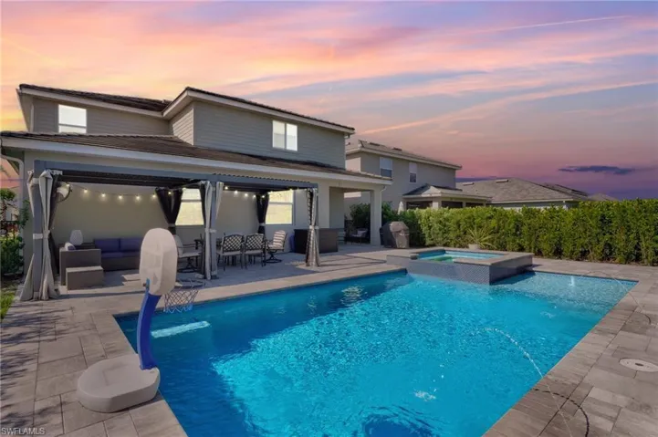 View of pool featuring outdoor lounge area, grilling area, a pool with connected hot tub, and a patio