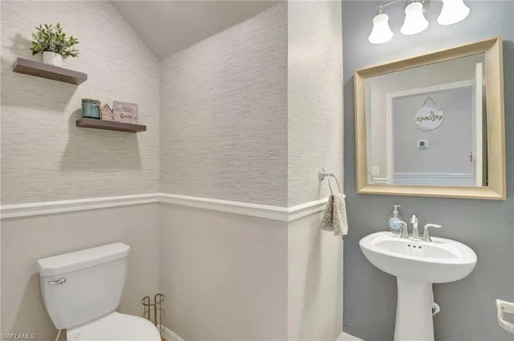 Half bath with toilet and vaulted ceiling