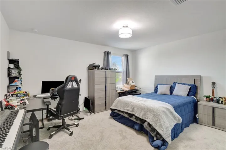 Bedroom featuring light carpet and visible vents