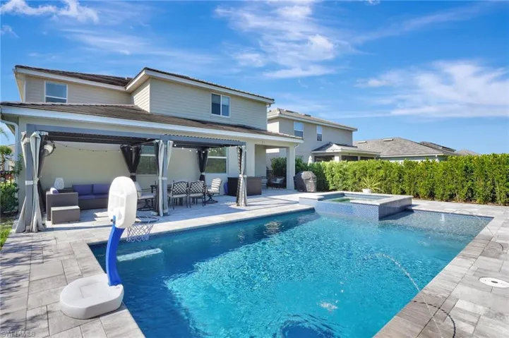 View of pool with a pool with connected hot tub, an outdoor living space, and a patio area