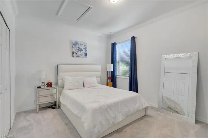 Carpeted bedroom featuring baseboards and crown molding