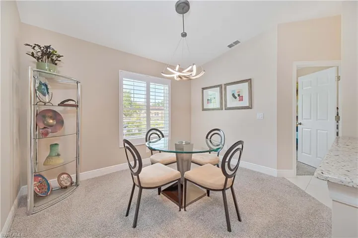 Dining room featuring baseboards, visible vents, a notable chandelier, and light colored carpet