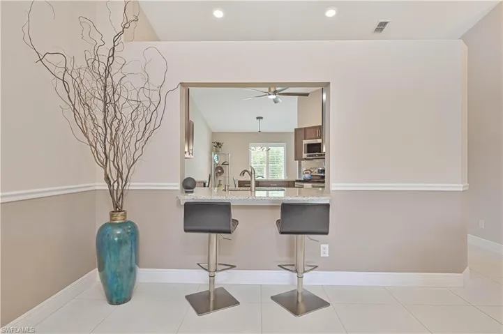 Kitchen featuring a peninsula, a kitchen breakfast bar, a sink, a ceiling fan, and appliances with stainless steel finishes