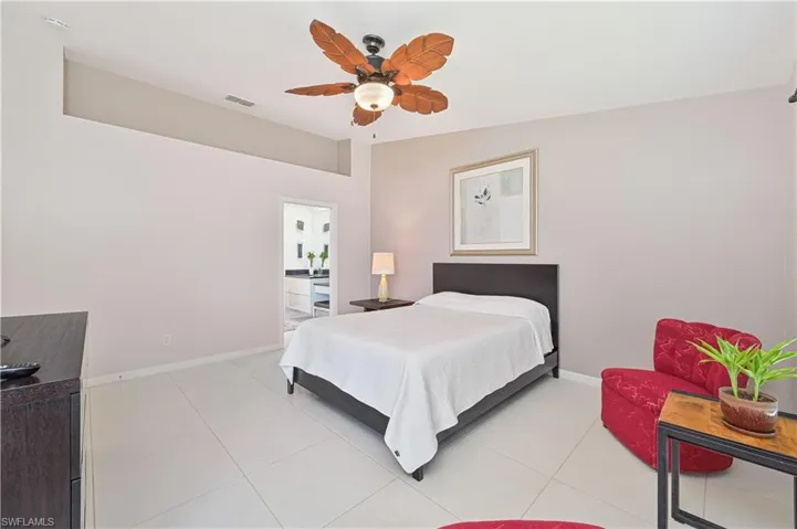 Bedroom with baseboards, a ceiling fan, visible vents, and light tile patterned floors