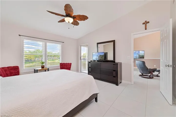 Bedroom featuring access to exterior, vaulted ceiling, baseboards, ceiling fan, and light tile patterned floors