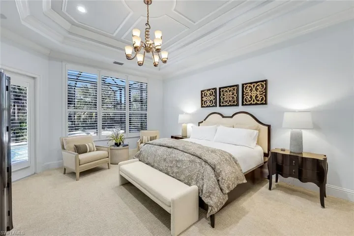 Primary Bedroom with seating area and pool access and views.