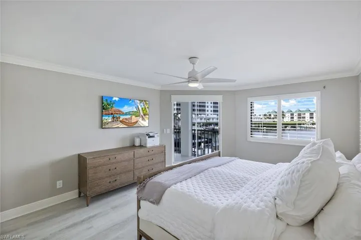 Bedroom featuring wood finished floors, crown molding, and ceiling fan