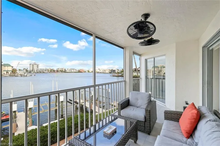 Balcony featuring a ceiling fan and a water view
