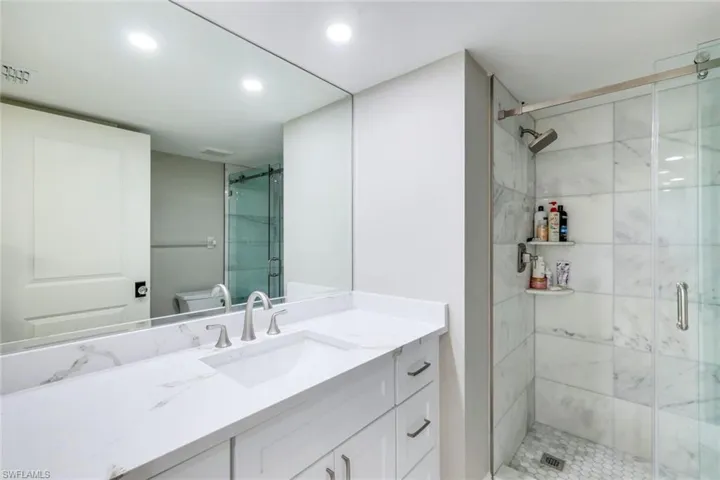 Bathroom with vanity, a stall shower, and recessed lighting