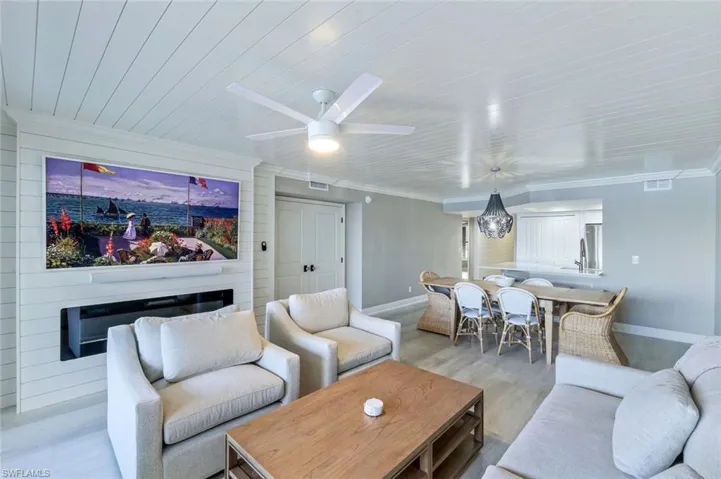 Living room featuring a ceiling fan and crown molding