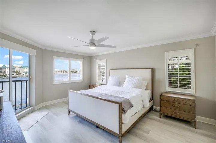 Bedroom featuring ornamental molding, access to outside, a ceiling fan, and wood finished floors
