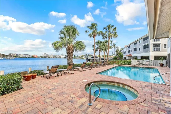 Community pool with a patio, a community hot tub, and a water view