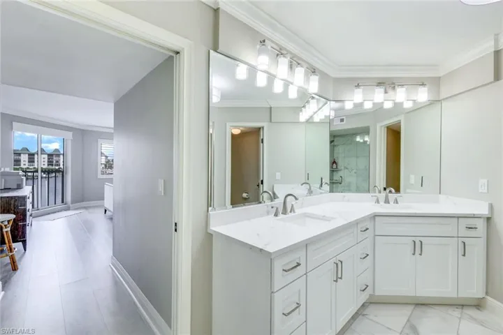 Full bath featuring ornamental molding, double vanity, and a stall shower