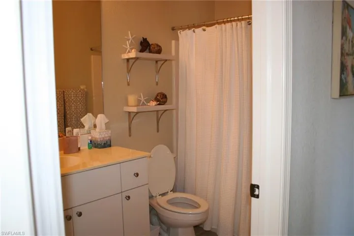 Bathroom featuring a vanity with an integrated sink, dual cabinet doors, and three drawers