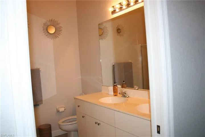Bathroom featuring a double vanity with integrated sinks, a light-toned countertop, and white cabinetry