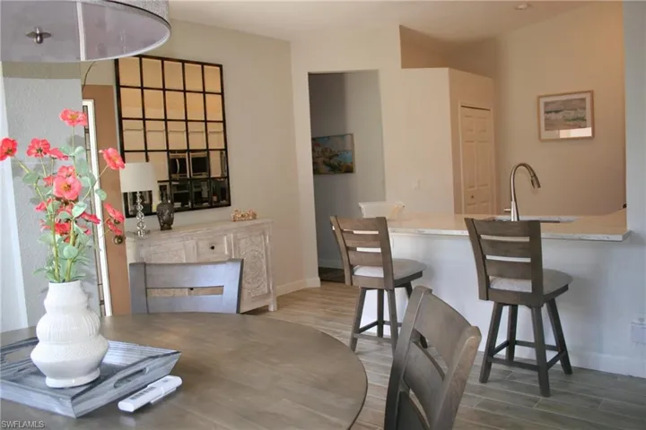 Kitchen bar with a gooseneck faucet, light-toned countertop, and recessed lighting