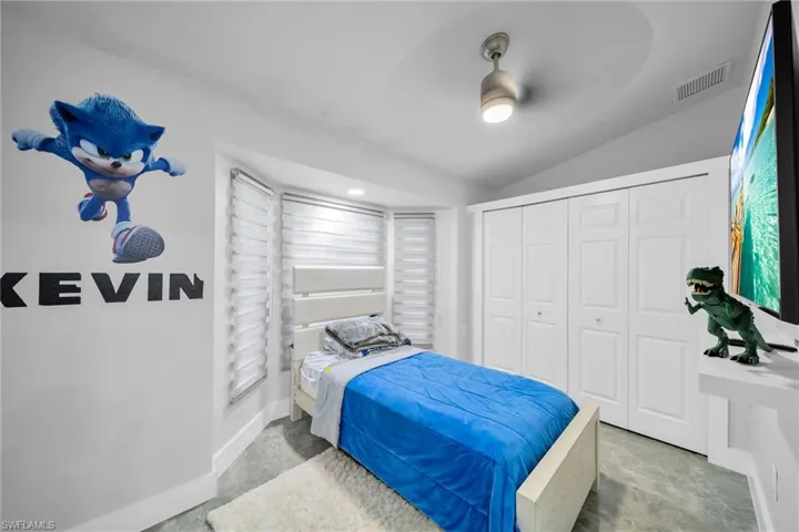 Bedroom featuring ceiling fan, a closet, and vaulted ceiling