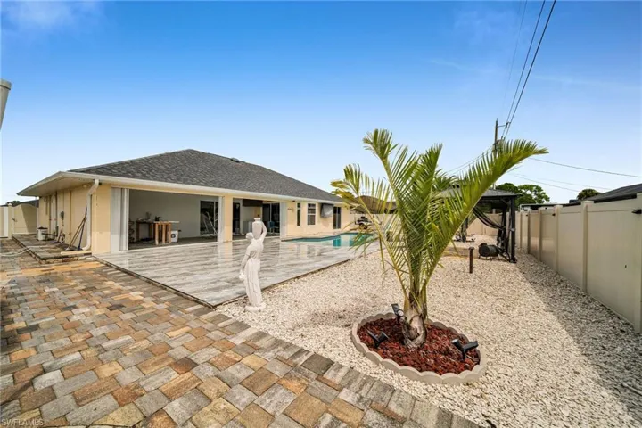 Back of property with a fenced in pool and a patio