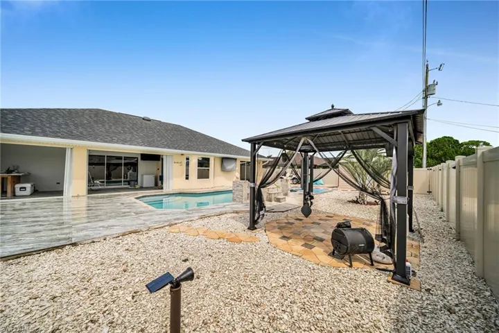 View of pool with a patio area and a gazebo
