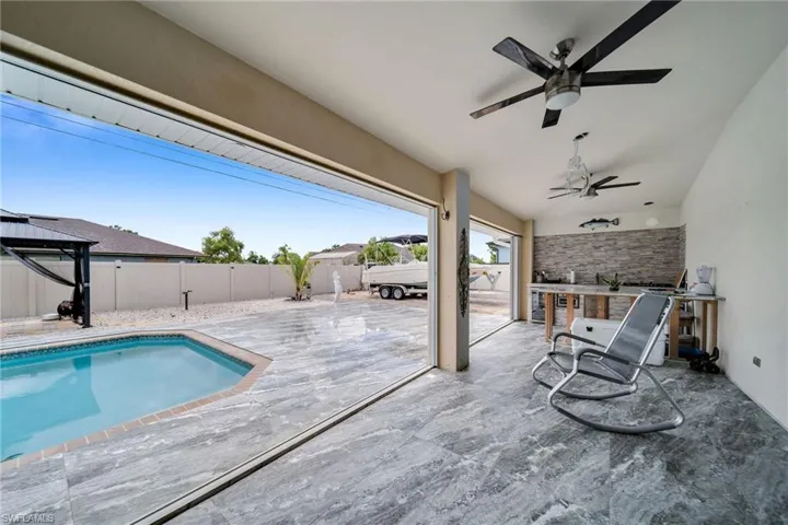 View of pool with a patio and ceiling fan
